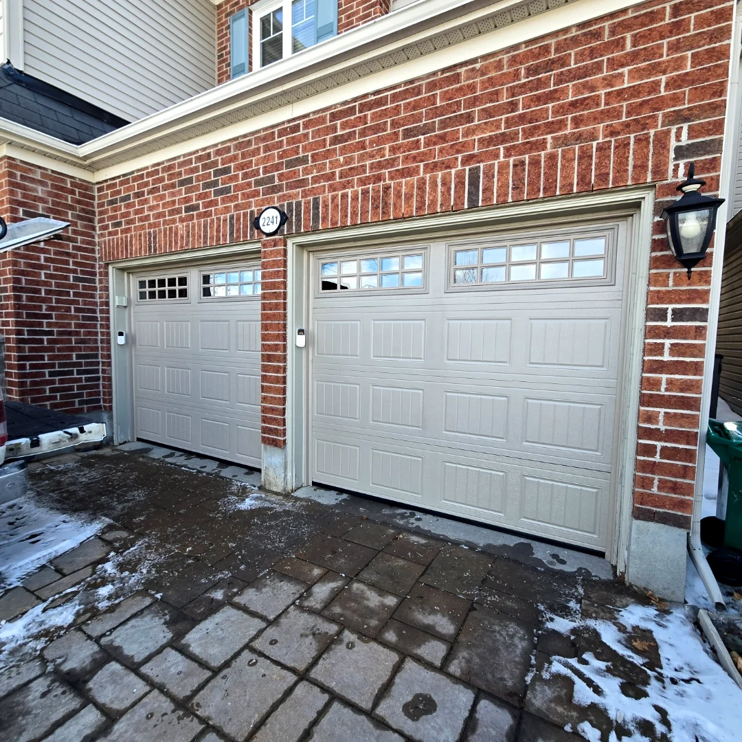 After — Brand-new insulated TOHO Coach House 400 garage door in Sandstone with carriage-style top windows installed by Liftime in Ottawa