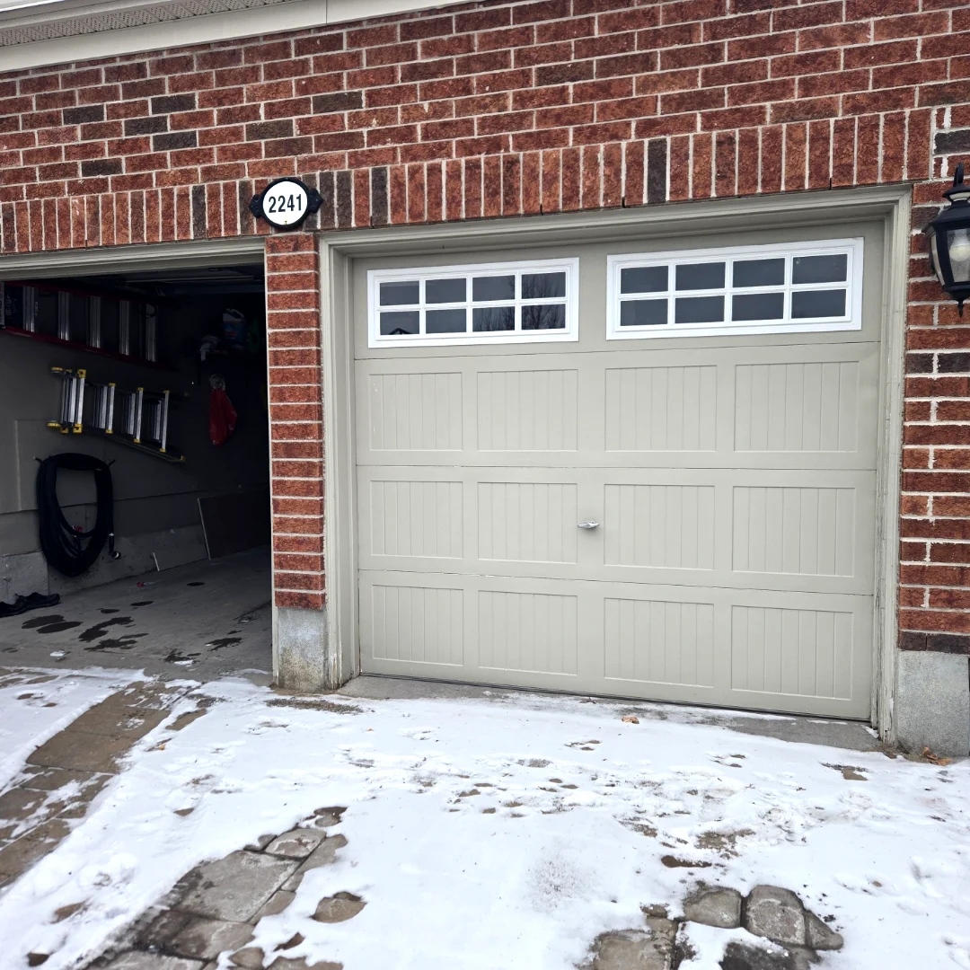 Before — Old non-insulated sandstone garage door on a red brick Ottawa home at #2241, snow on the driveway