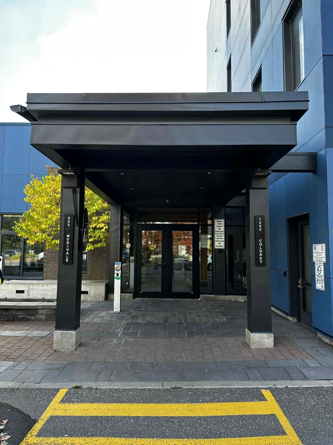 After — The same Merivale commercial entrance fully wrapped in clean dark aluminum cladding by Liftime, modern finish, no more exposed wood