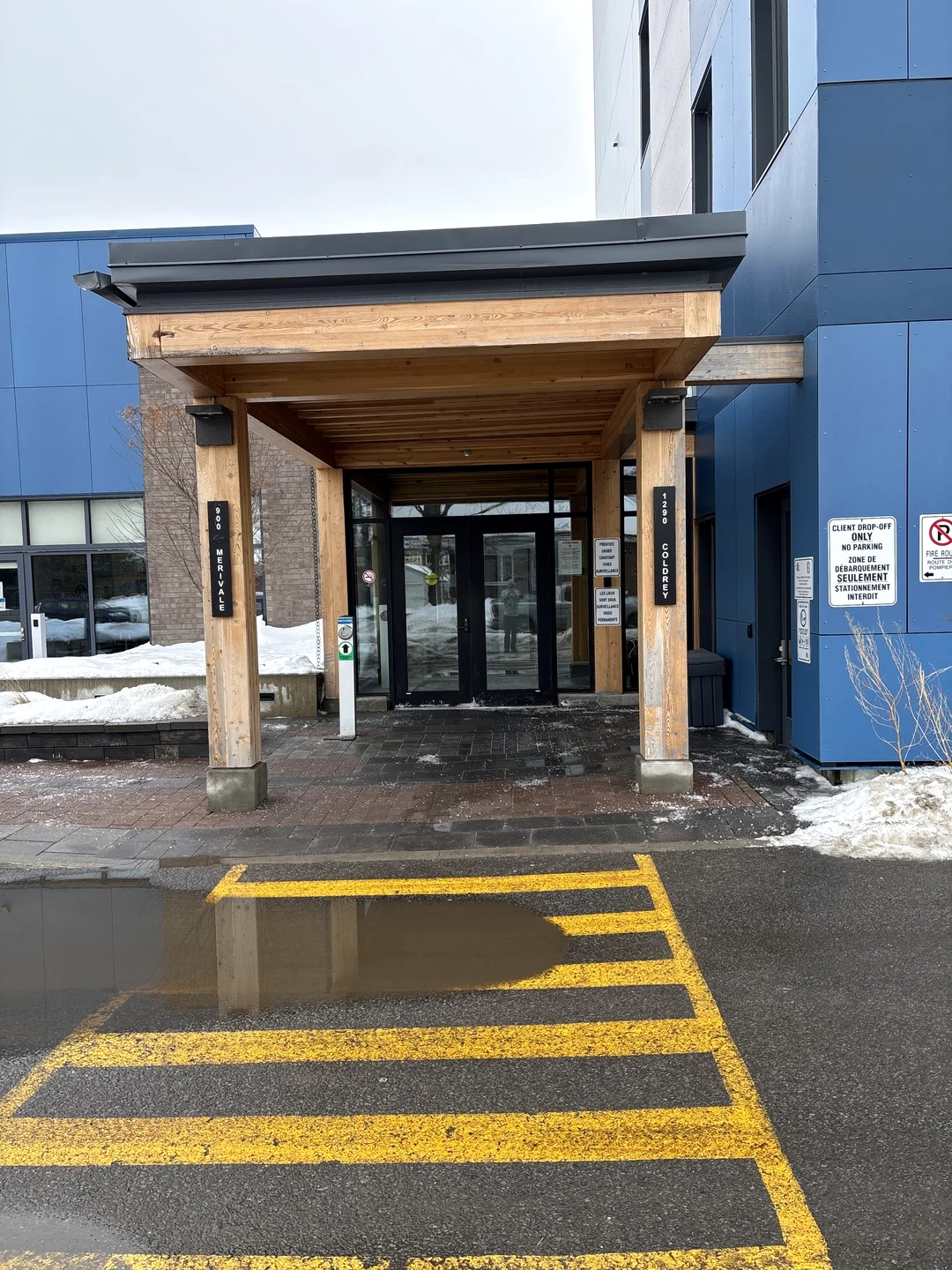 Before — Exposed wood beams and posts at a commercial building entrance on Merivale, Ottawa, before Liftime capping