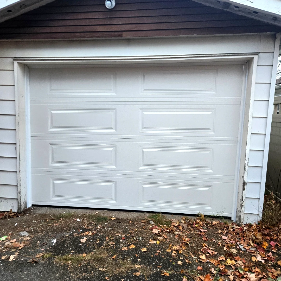 After — New TOHO Heritage 500 long-panel garage door in White installed cleanly on the same Ottawa detached garage by Liftime