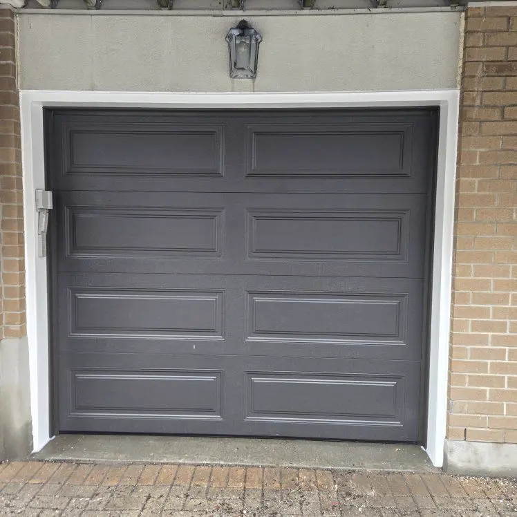 After — New charcoal raised-panel single-car garage door installed by Liftime on the same brick Ottawa home