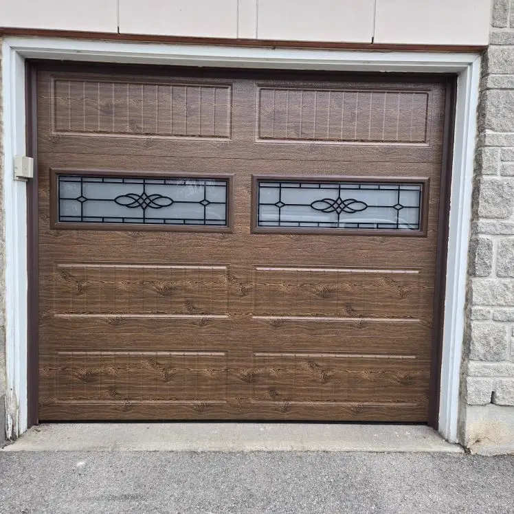 After — New faux-wood brown carriage garage door with decorative glass inserts installed by Liftime Ottawa