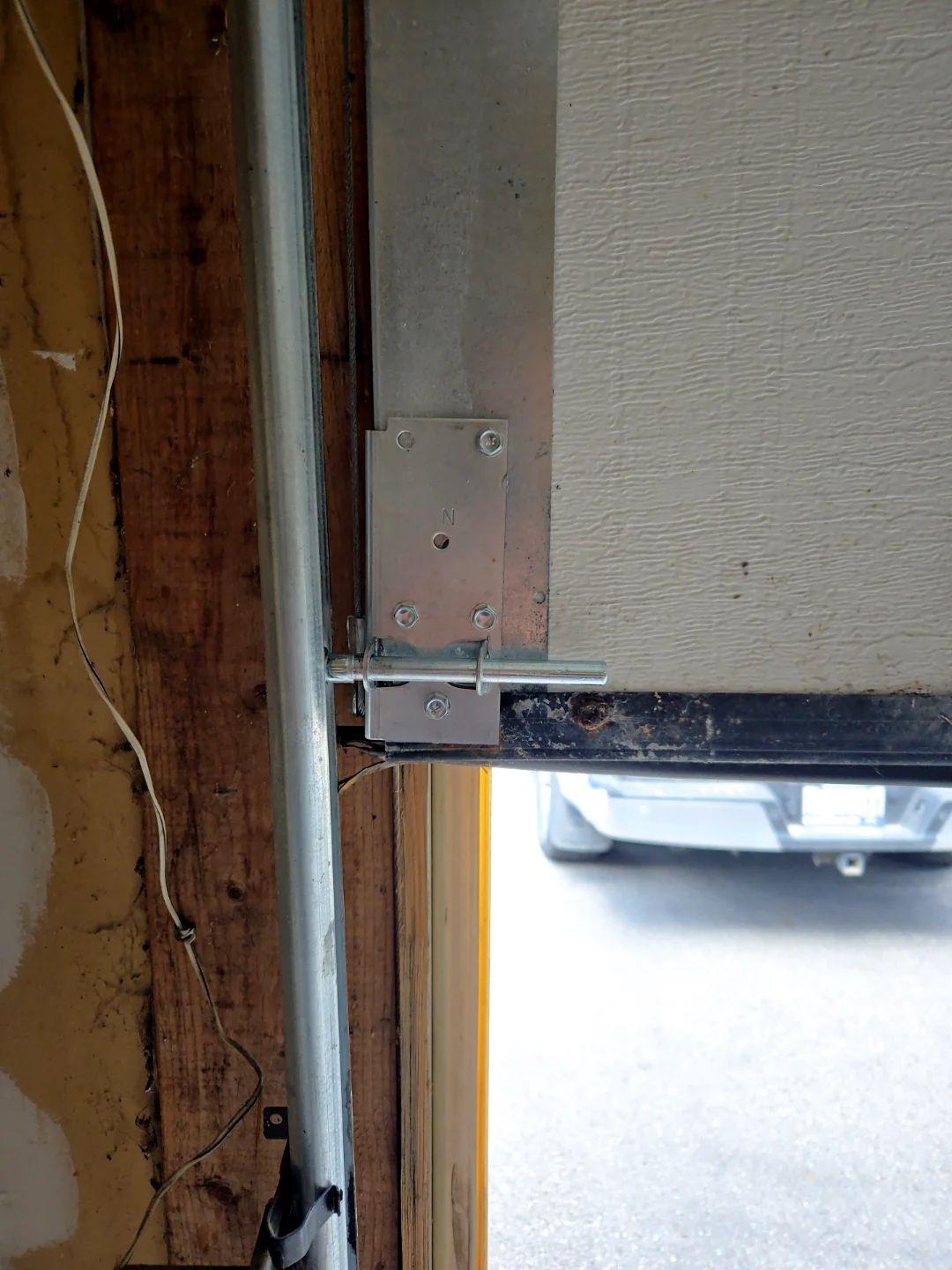 Same Ottawa garage door after Liftime cable repair — brand-new bottom bracket and properly tensioned galvanized cable, clean hardware