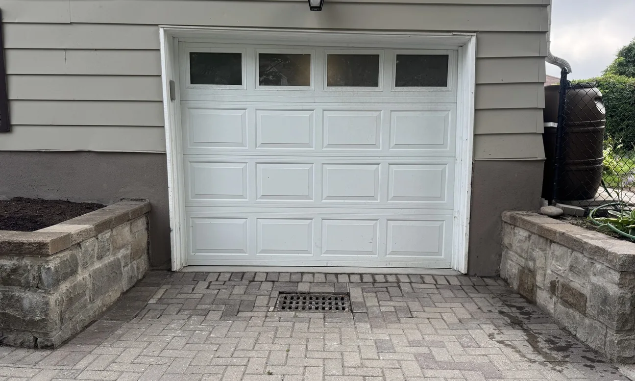 Garage door frame before aluminum capping — worn paint and exposed wood trim