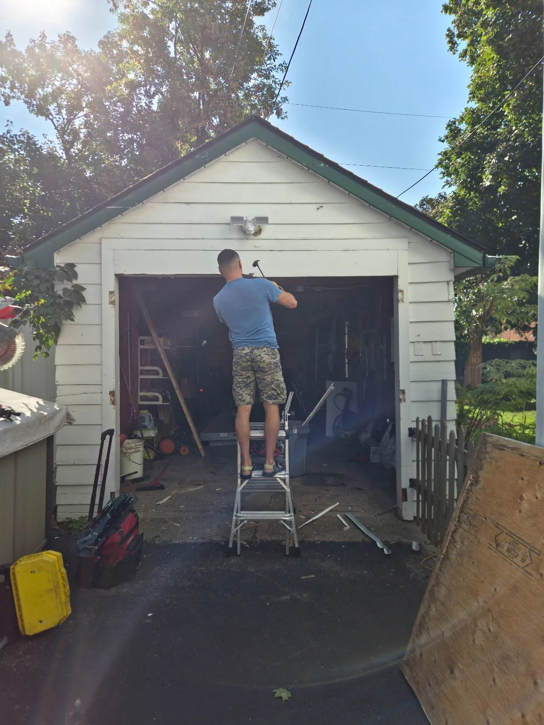 Liftime owner Michael on a ladder installing aluminum capping around an Ottawa garage door frame