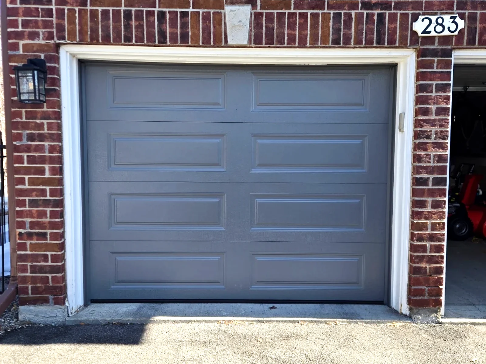 TOHO Heritage 500 charcoal long-panel garage door installed by Liftime on a red brick Ottawa townhome