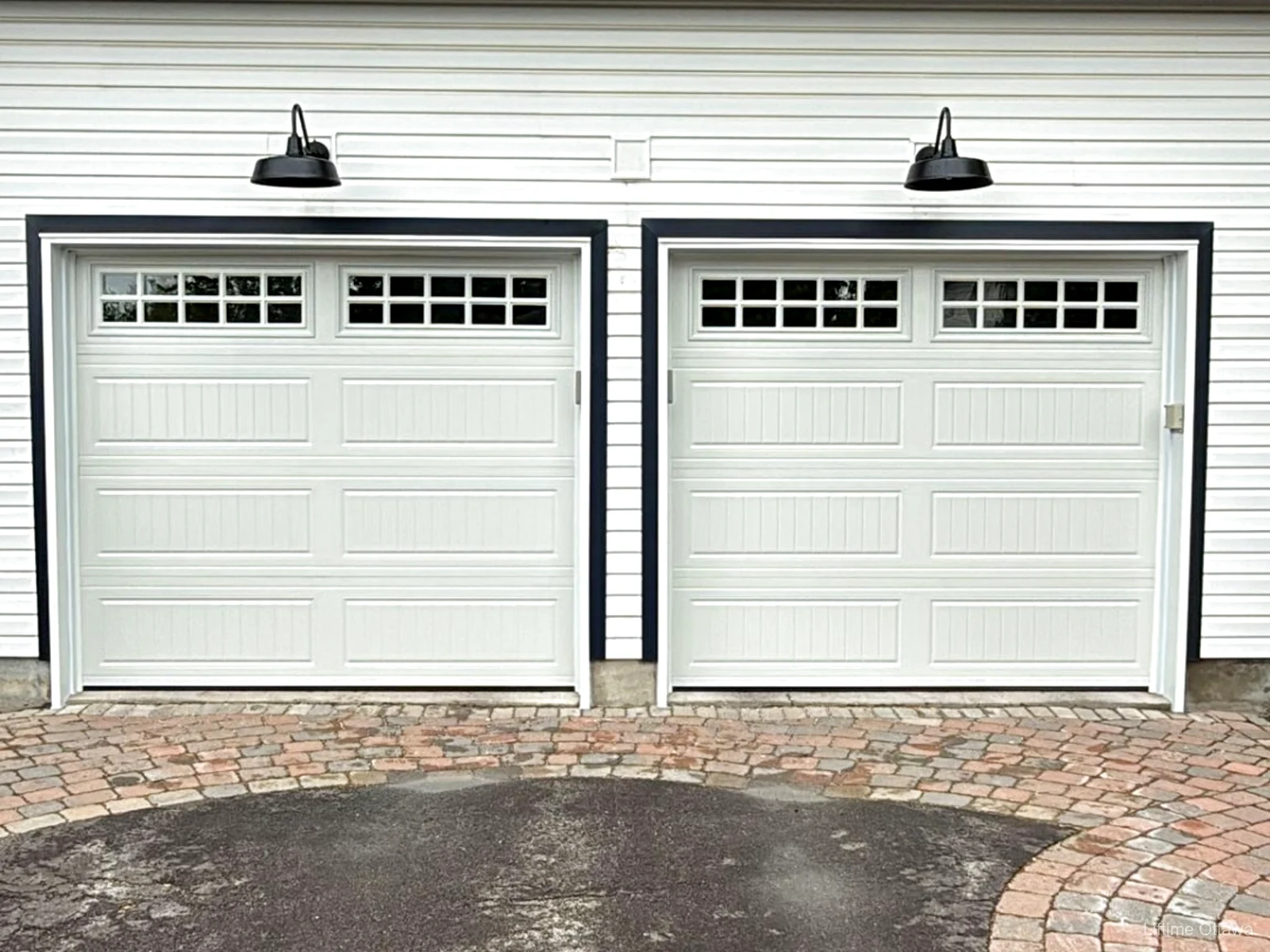 TOHO Carriage 600 double white garage doors with L01 Stockton-10 windows and capping on a board-and-batten Ottawa home, installed by Liftime