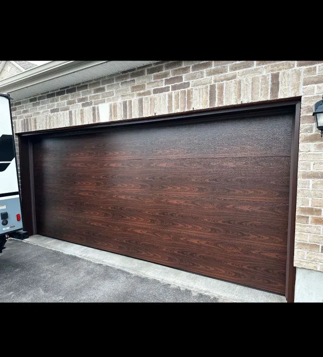 Double-car dark walnut woodgrain flush garage door on a stone Ottawa home by Liftime