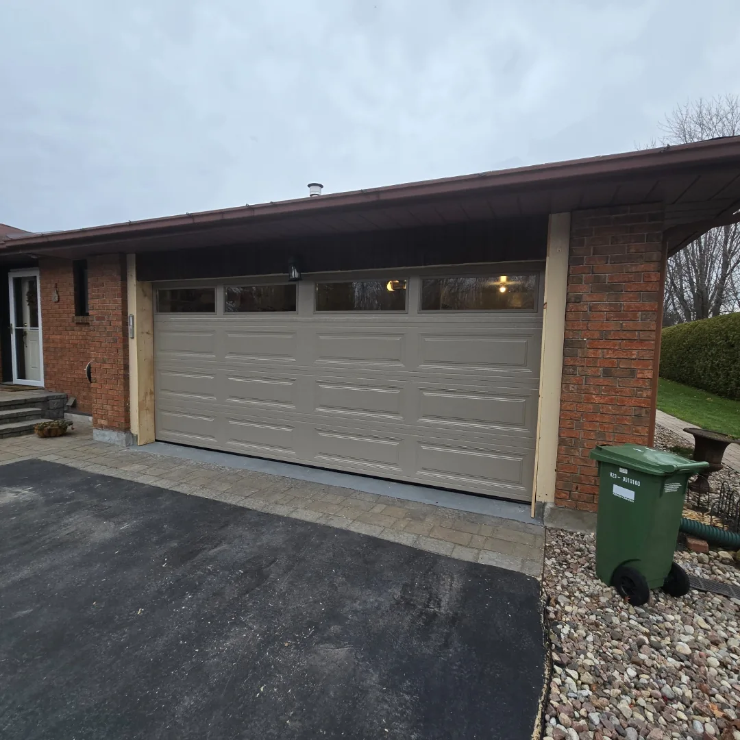 Sandstone raised-panel garage door with top windows on brick Ottawa home, installed by Liftime