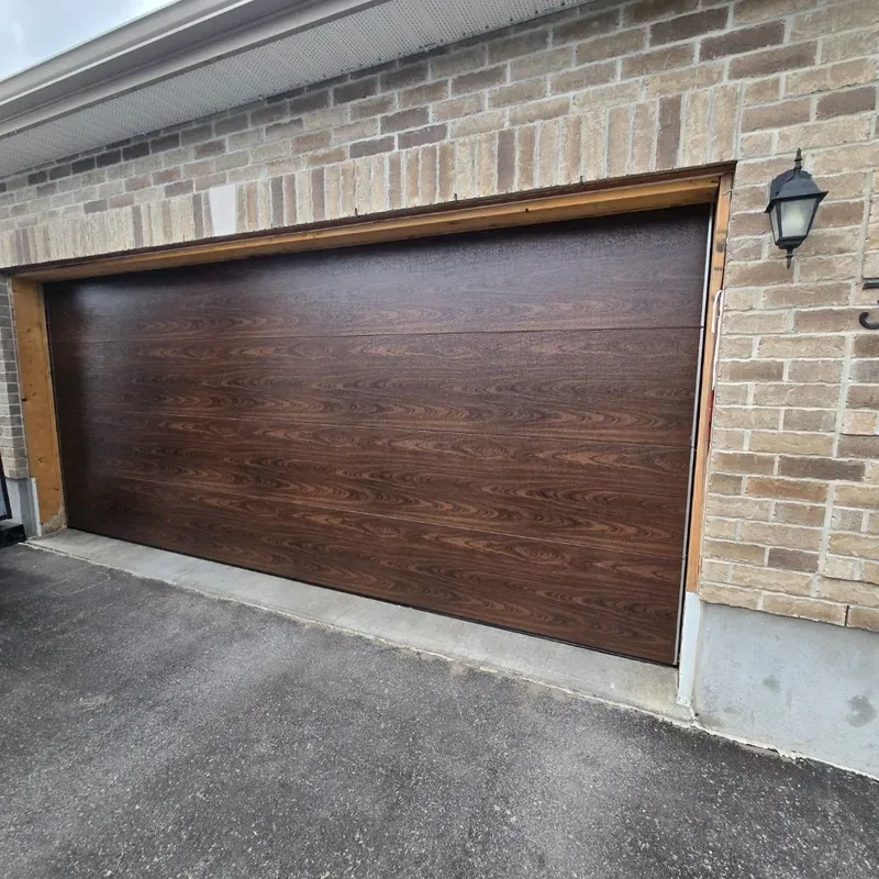 Dark woodgrain TOHO garage door on brick house in Ottawa — installed by Liftime May 2026