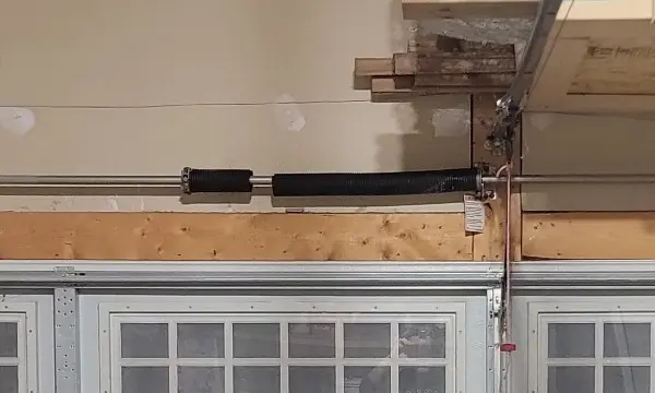 Broken garage door torsion spring with a visible gap between the separated coils